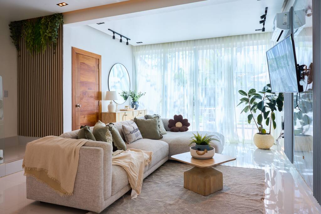 Spacious open living area with cozy sofa, Smart TV, and direct access to the outdoor space.