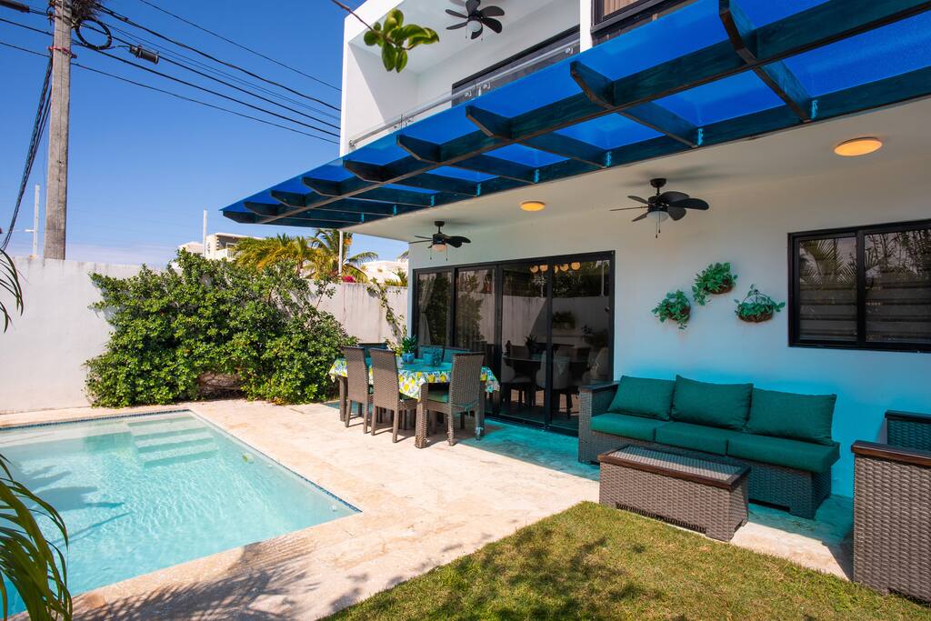 Covered outdoor dining and lounge area by the private pool, perfect for relaxing and entertaining in a shaded tropical setting.