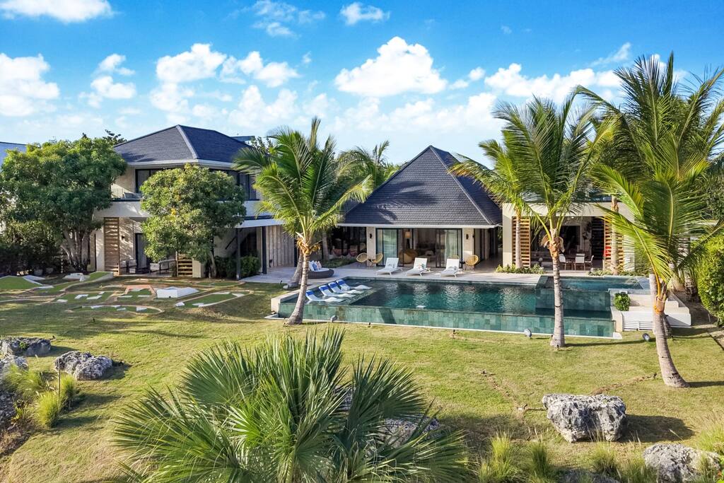 Aerial view of the property, pool area, and garden with mini golf