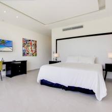 Villa Palma: Bedroom 2 (upstairs) with King bed, air-conditioning, TV, desk and chair, closet, ensuite bathroom with shower and tub, and access to a balcony with pool- and golf views