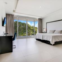 Villa Palma: Bedroom 4 (upstairs) with King bed, air-conditioning, TV, desk and chair, closet, ensuite bathroom with shower, and balcony with pool- and golf views