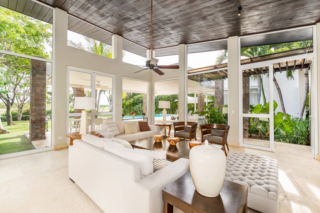 The living room in the villa has ceiling-to-ceiling windows and is very spacious and bright.