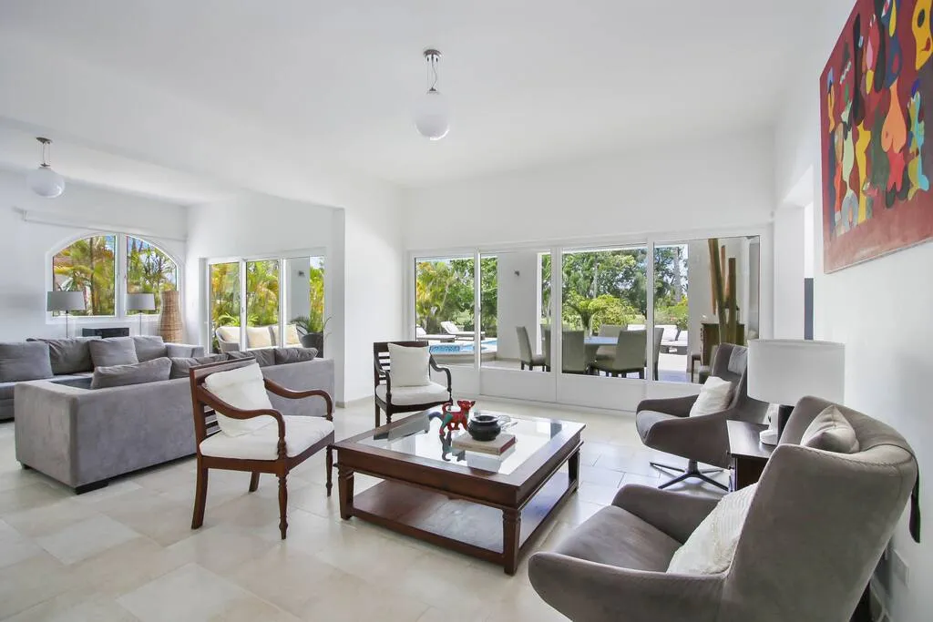 Living room with large windows overlooking the garden and pool