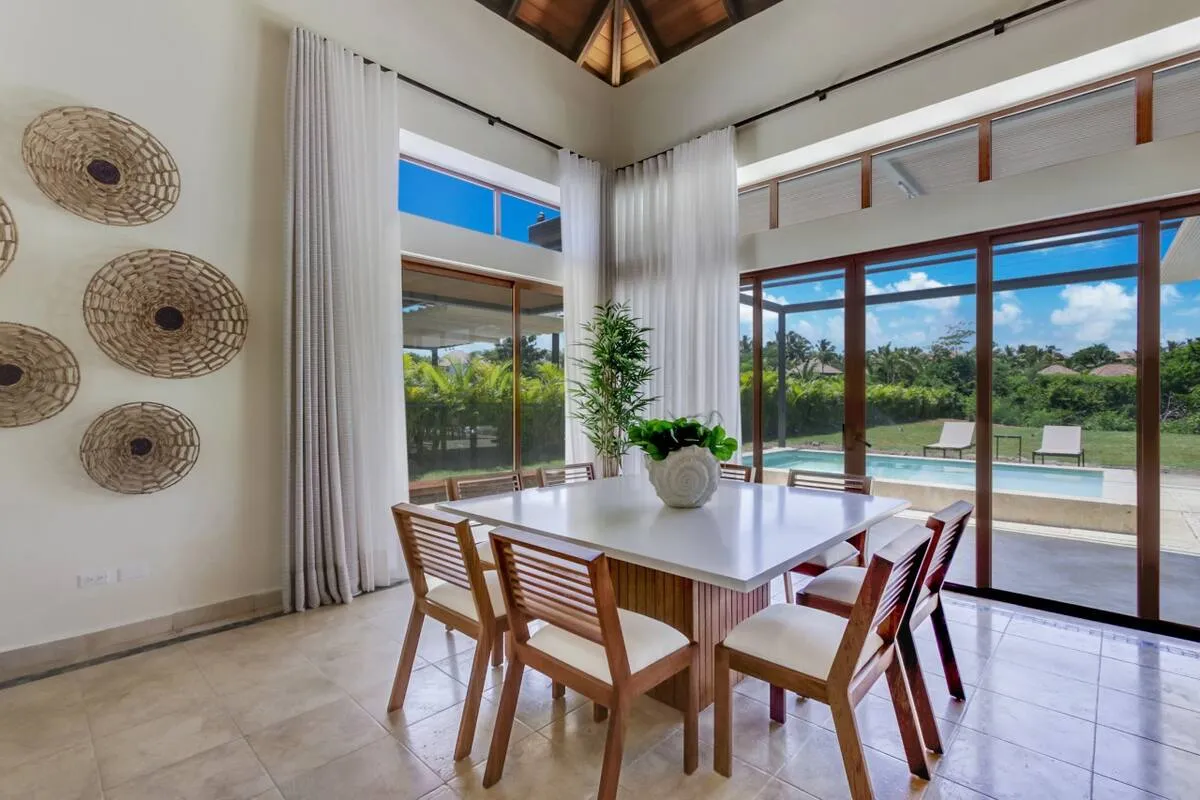 The dining room has large windows overlooking the pool and nature